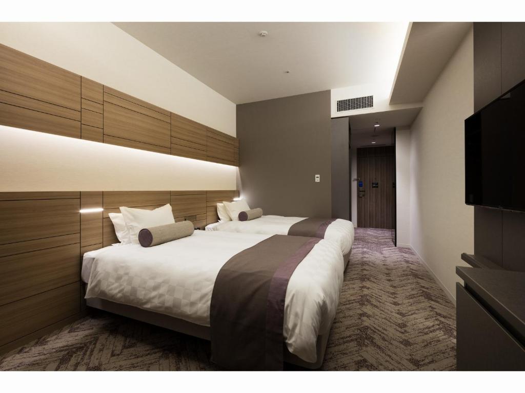 Postel nebo postele na pokoji v ubytování Nihon Seinenkan Hotel