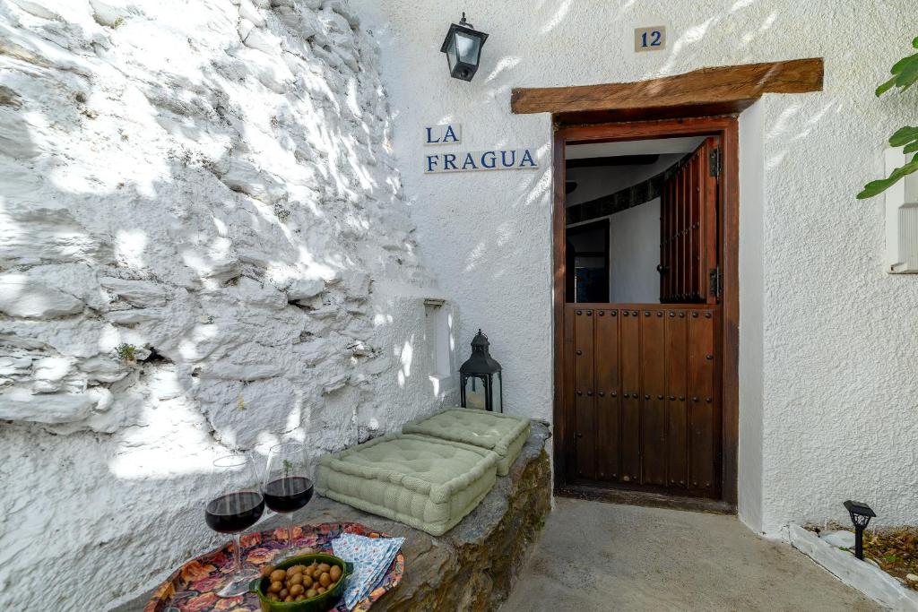 - un bâtiment avec une porte et une table avec des fruits dans l'établissement Casa La Fragua, à Capileira