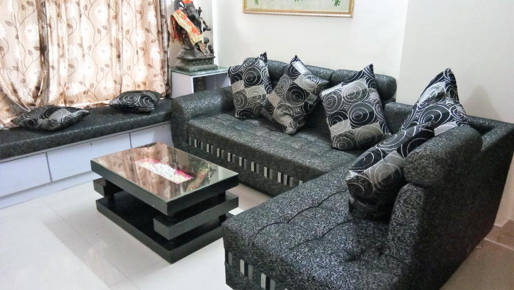a living room with two couches and a coffee table at Dragonfly Apartments Emerald in Mumbai