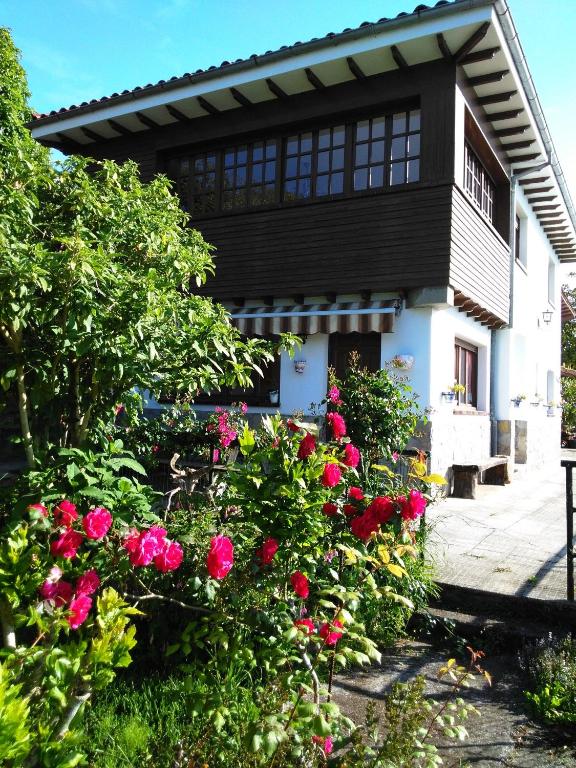a house with pink roses in front of it at Casa Tirador in San Martin del Mar