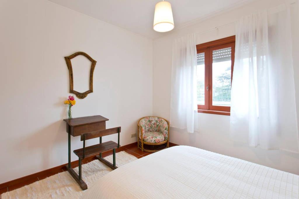 ポルトにあるCamarao Apartmentのベッドルーム1室(ベッド1台、テーブル、窓付)