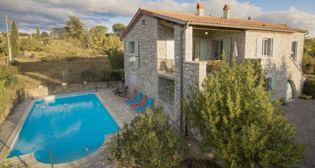 an external view of a house with a swimming pool at Les 23 Mûriers in Chauzon