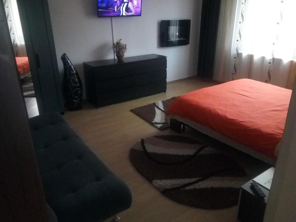 a bedroom with a bed and a chair and a television at Casa Aurora in Turda