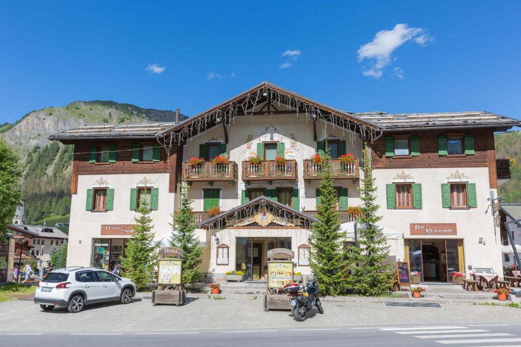 un bâtiment avec une voiture garée devant lui dans l'établissement Hotel Pontiglia, à Livigno