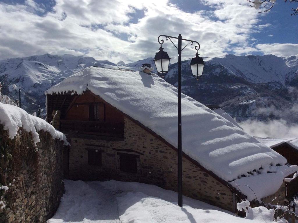 a snow covered roof of a house with a street light at Chalet Auris in Auris