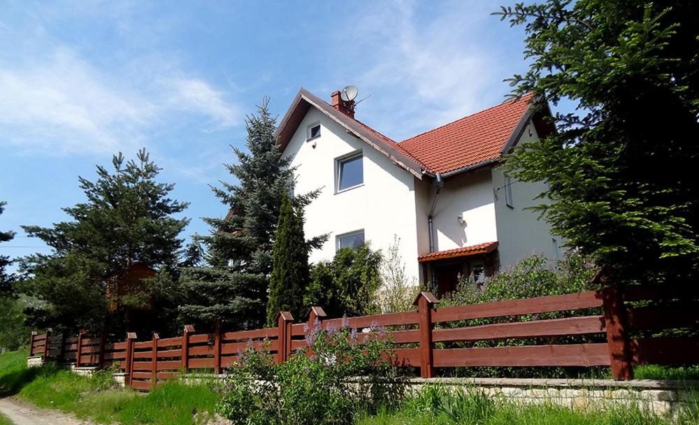 una casa bianca con una recinzione davanti di Dom na wzgórzu a Polanica-Zdrój