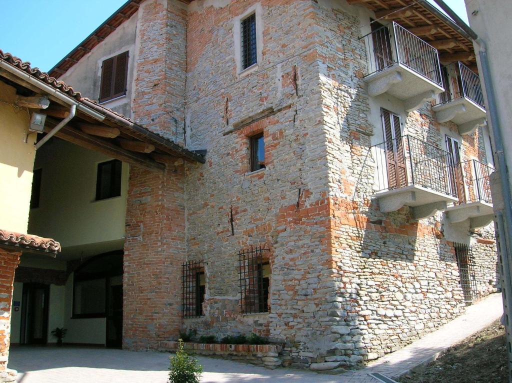 - un grand bâtiment en briques avec 2 balcons dans l'établissement Agriturismo La Cantina, à Farigliano