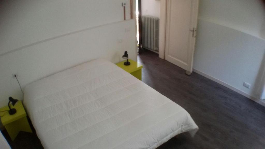 莫利亞諾威尼托的住宿－Casa Martini，卧室配有白色的床和黄色的桌子