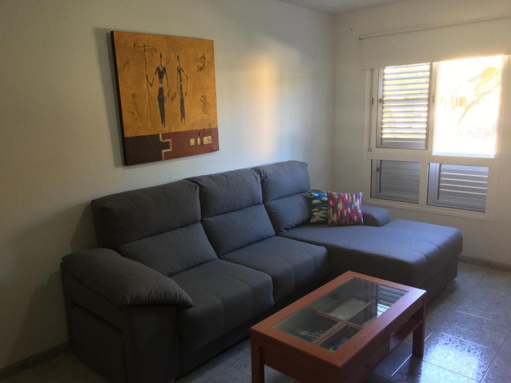 a living room with a blue couch and a coffee table at Apartamento Los Llanos 1-L1 in Vecindario