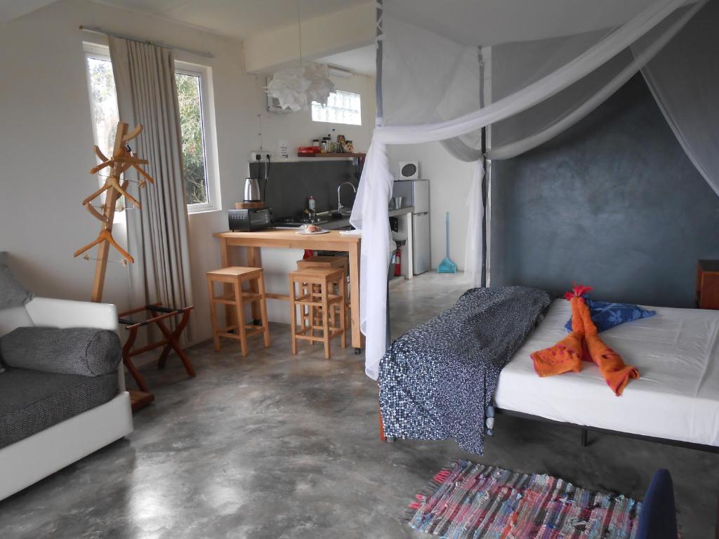 Rodrigues Island的住宿－阿弗爾公寓，一间卧室配有一张床,厨房配有桌子