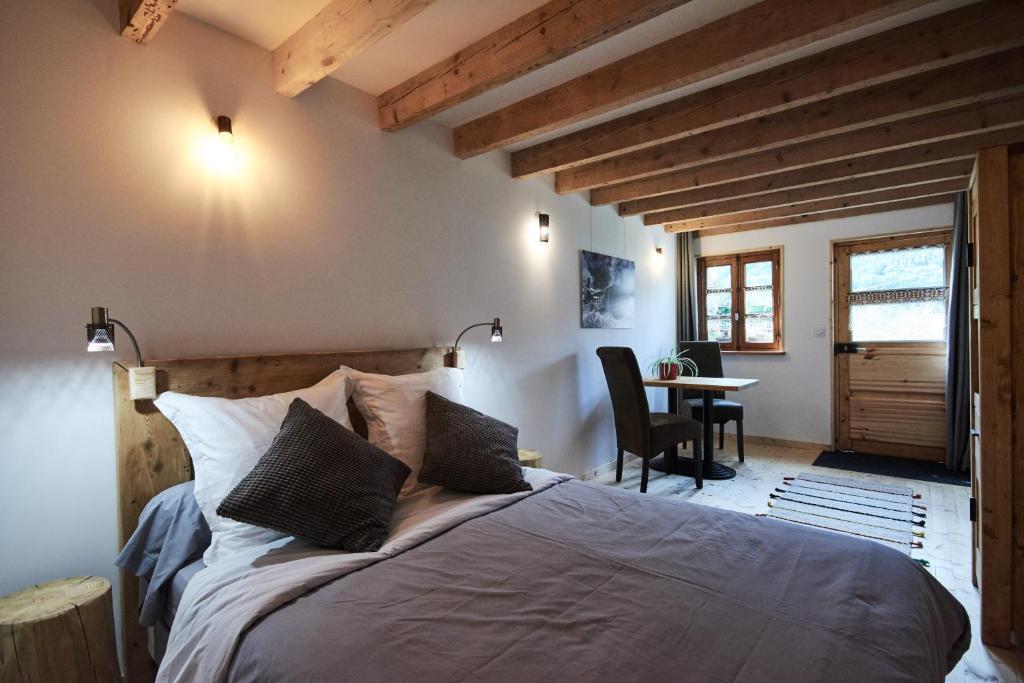 um quarto com uma cama grande e uma mesa em La Foyère em Aime La Plagne