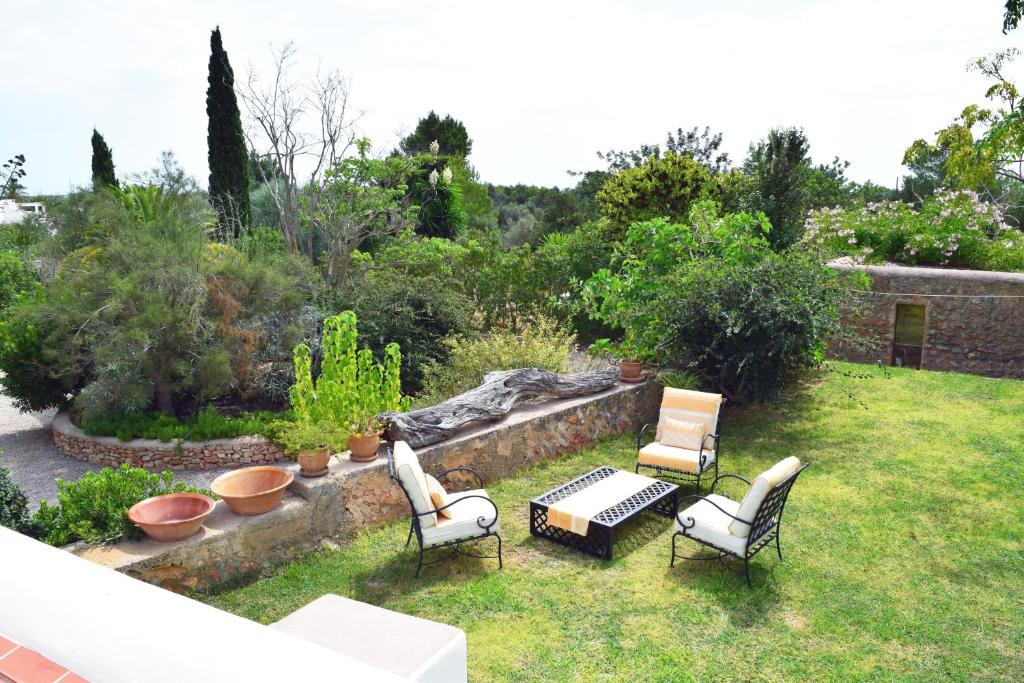 dziedziniec z krzesłami i stołem oraz ogród w obiekcie Agroturismo Ca na Joaneta w mieście Santa Eularia des Riu