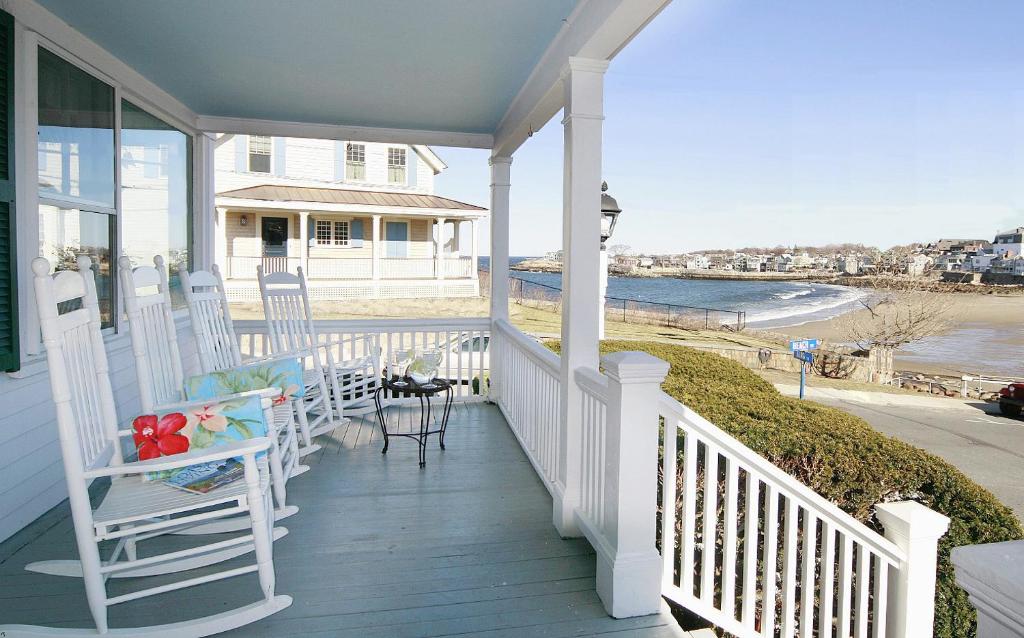a porch with chairs and a table on a house at Beach & King Street Inn in Rockport