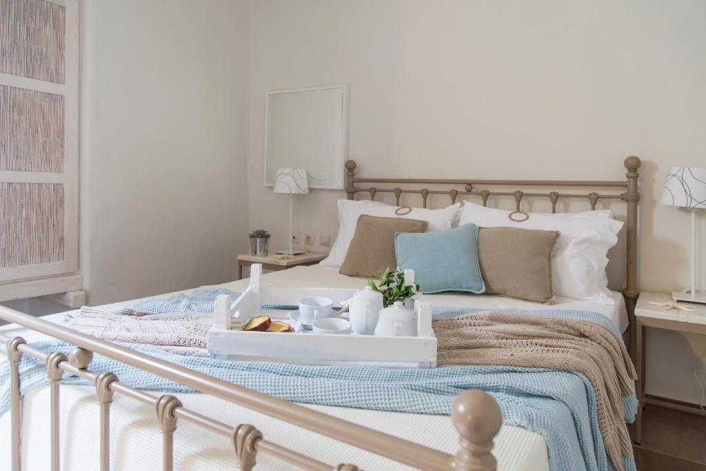 a bedroom with a bed with a tray of food on it at Portes Houses in Koufonisia