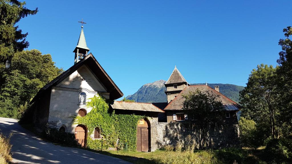 une ancienne église avec du lierre sur le côté d'une route dans l'établissement Château du Vigny - Gîte, à Saint-Michel-de-Maurienne