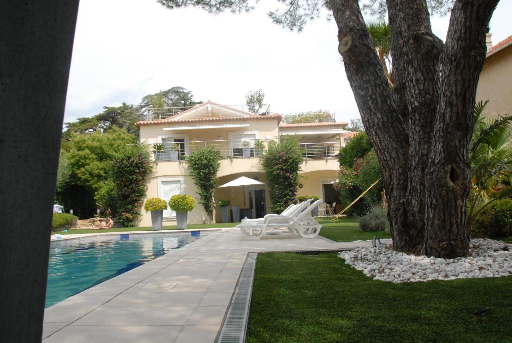 une maison avec une piscine et un arbre dans l'établissement Sainte Maxime 4 pièces, à Sainte-Maxime