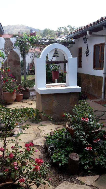 een tuin met potplanten en een gebouw met een spiegel bij Posada Guasu in Samaipata