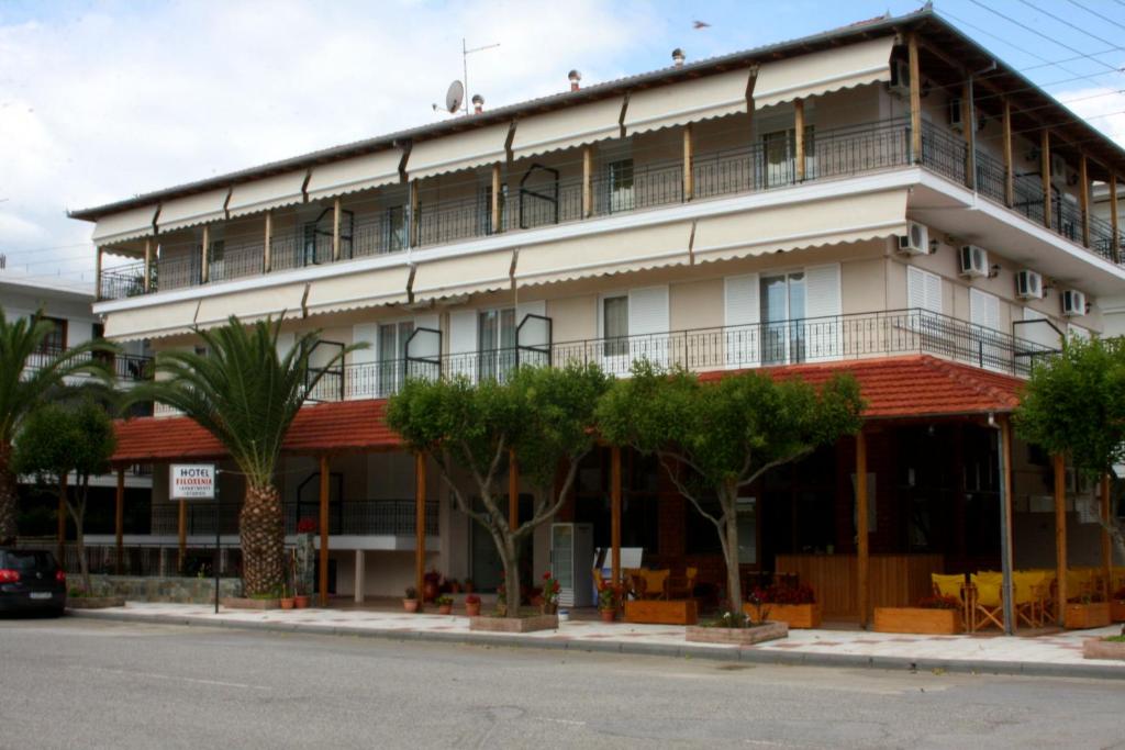 um grande edifício branco com árvores em frente em Hotel Filoxenia em Neoi Poroi