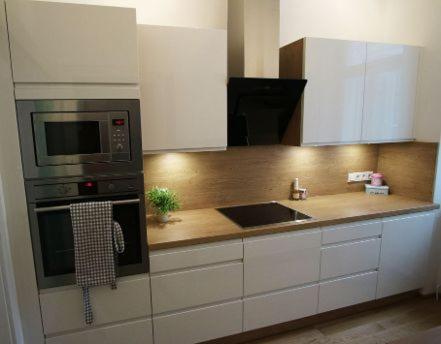 a kitchen with white cabinets and a microwave and a sink at Kurzzeit-Apartment Nussdorf in Vienna