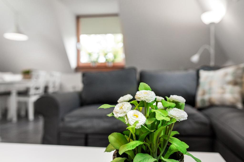 un jarrón con flores blancas sobre una mesa en la sala de estar en Vakantieappartementen centrum Oudewater, en Oudewater