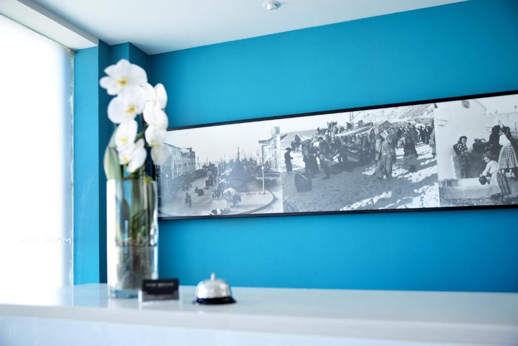 a vase with white flowers on a shelf in a room at Hotel Mar Bravo in Nazaré