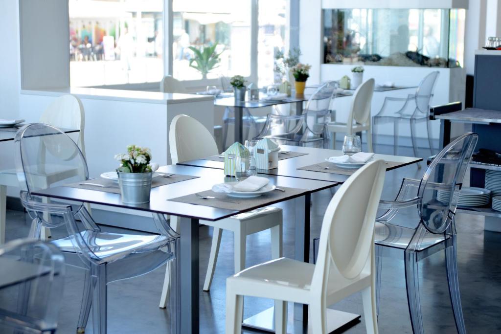 a dining room with white chairs and a table at Hotel Mar Bravo in Nazaré