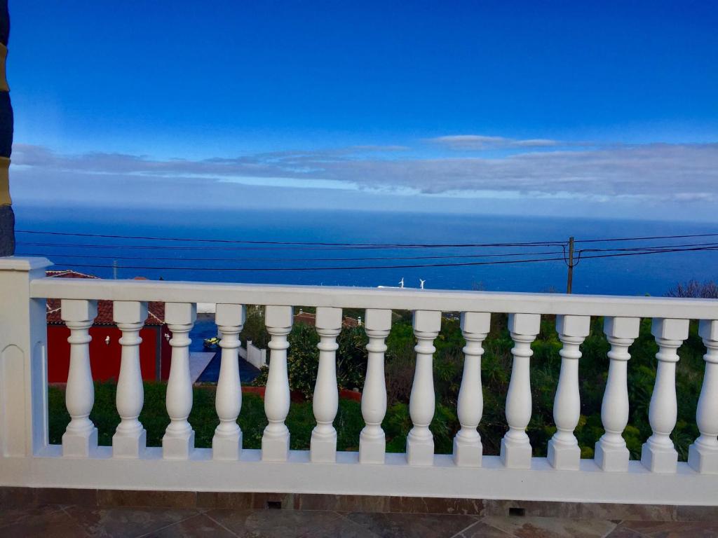 a white fence with the ocean in the background at Costa Este House in Monte de Breña