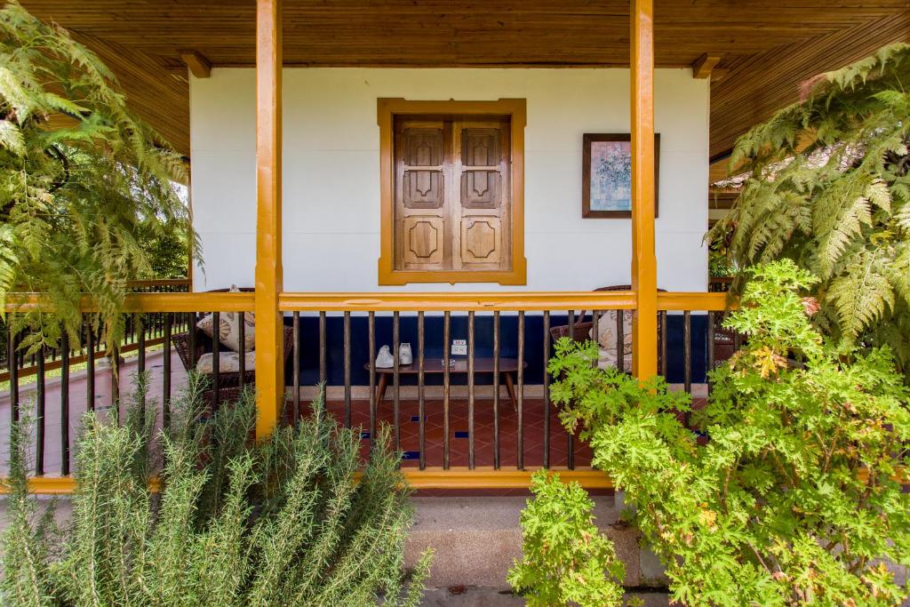 ein Haus mit einer Veranda mit Holztür in der Unterkunft El Laurel Finca Agroturistica in Quimbaya