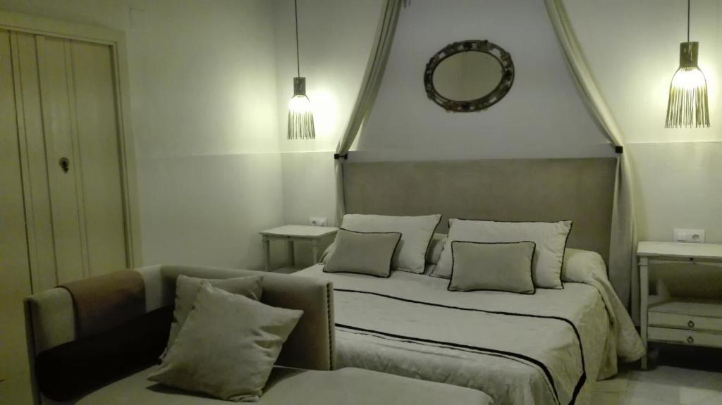 ヘレス・デ・ラ・フロンテーラにあるEstudio Bizcocherosのベッドルーム(ベッド1台、ソファ、鏡付)
