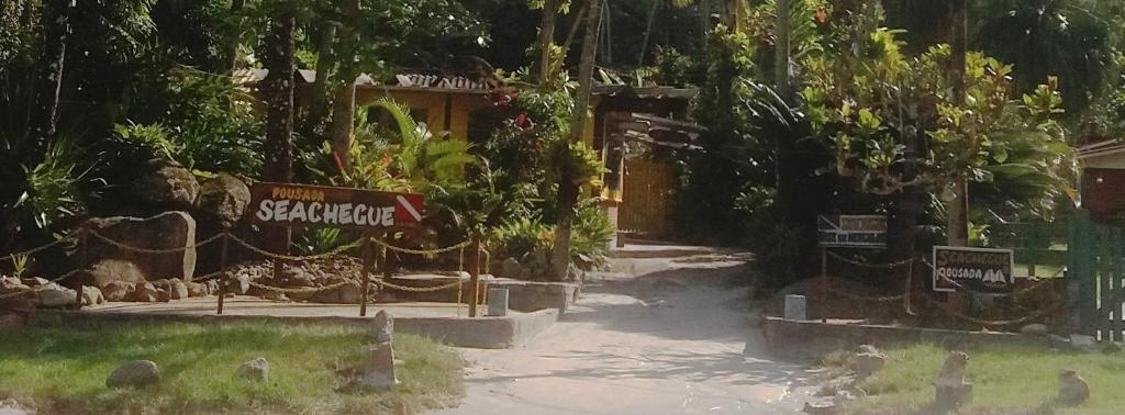 a garden with a sign that says gardening and plants at Pousada Seachegue in Ubatuba
