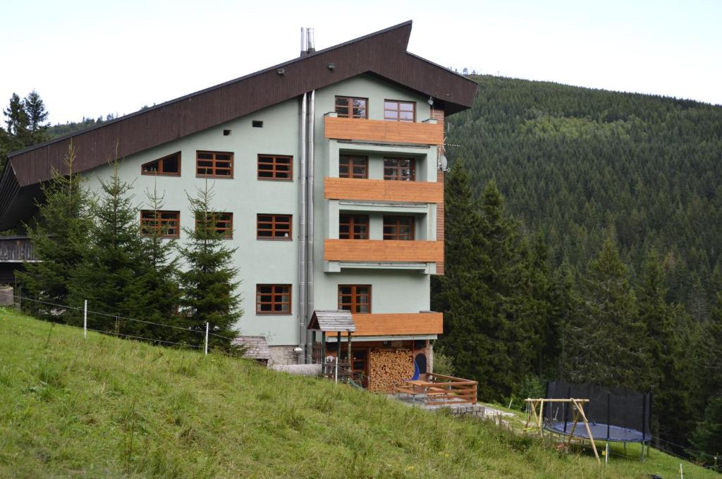 un edificio al lado de una colina en Apartmán v Srdci Hor Cihlářka, en Pec pod Sněžkou