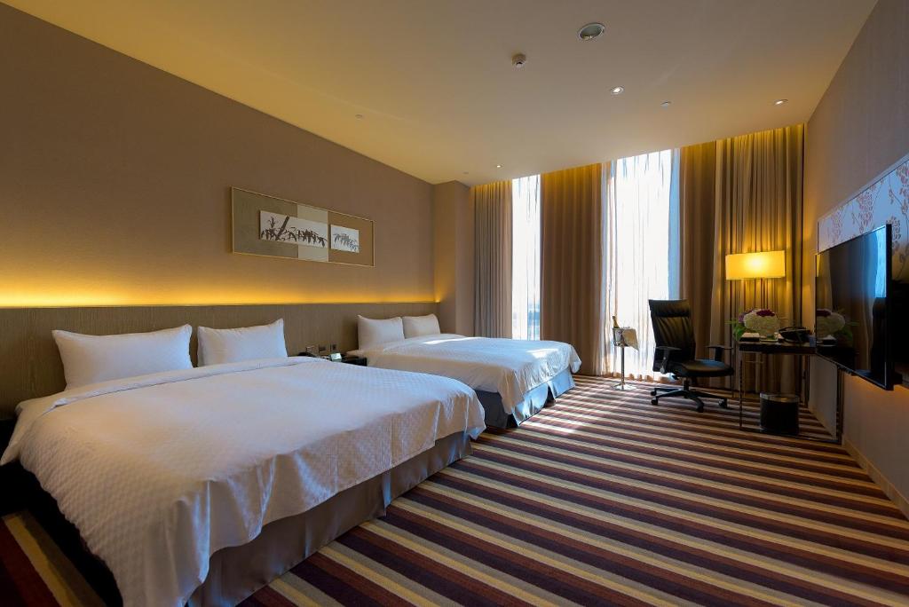 a hotel room with two beds and a television at Grand Royal Hotel in Toufen