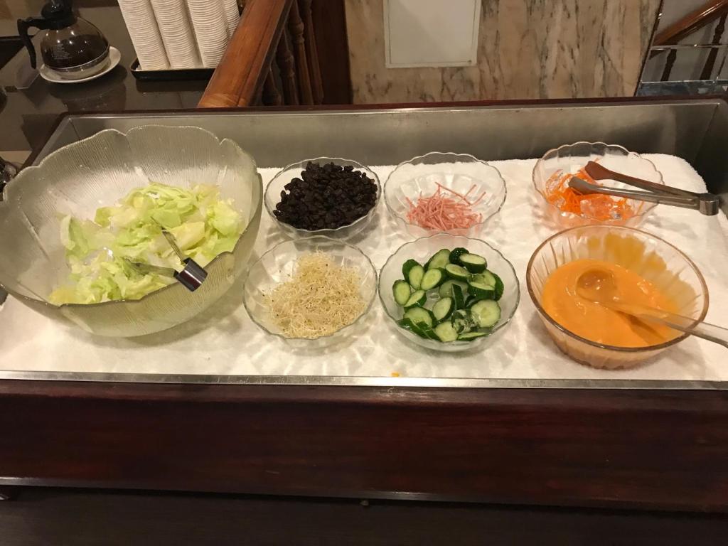 a counter with four bowls of vegetables and other ingredients at Abbo Hotel in Tainan