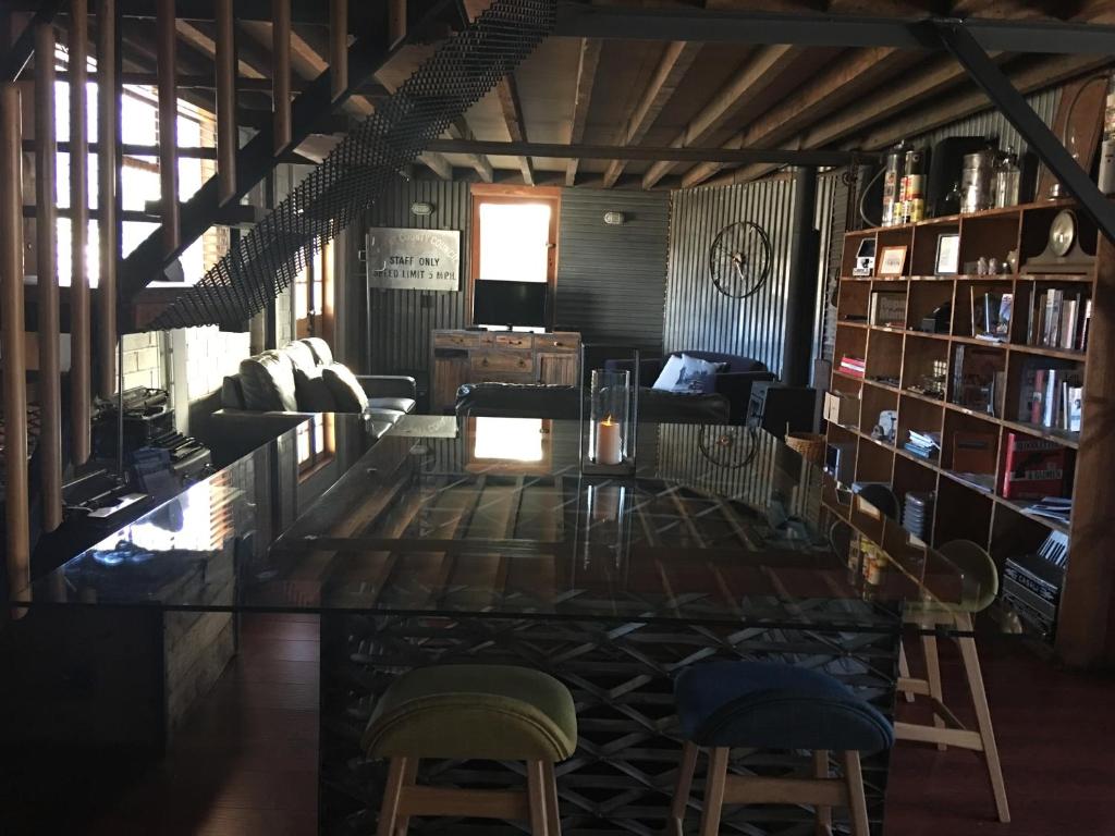 a living room with chairs and a table and bookshelves at The Workshops Clyde in Clyde