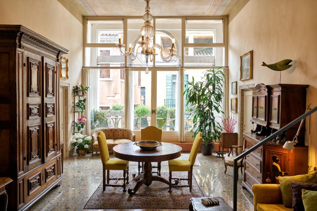 a living room with a table and chairs and a large window at Campiello Zen B&B in Venice