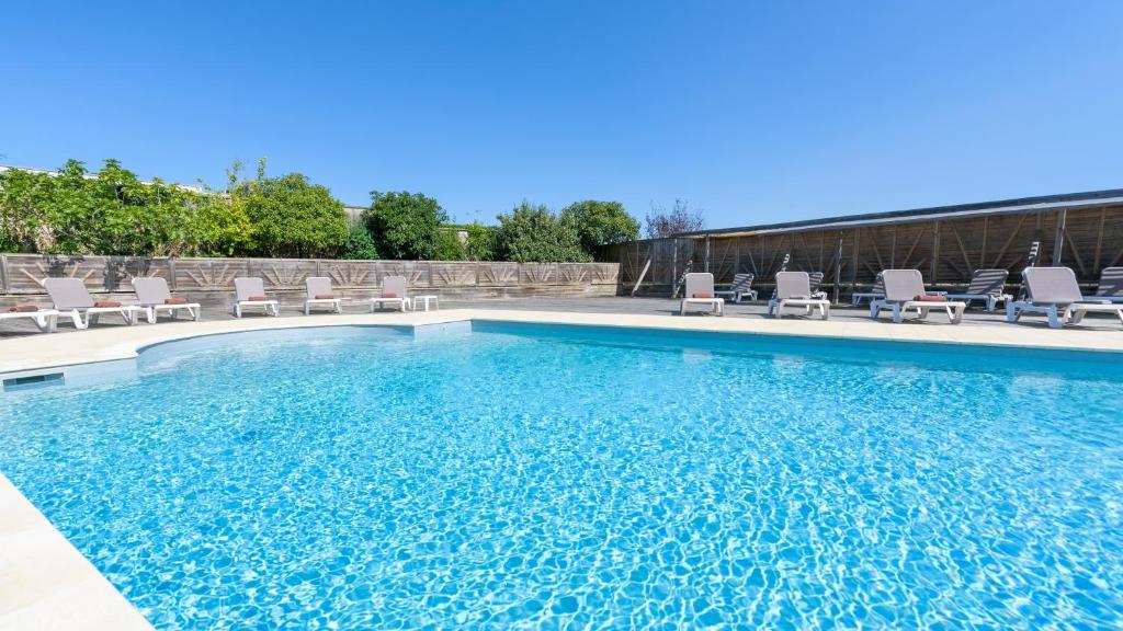 a swimming pool with chairs and a swimming pool at Chateau Du Boisniard in Chambretaud