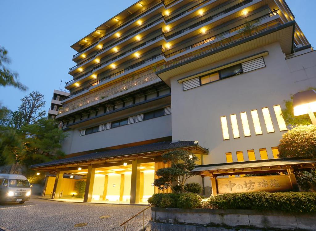 duży budynek z samochodem zaparkowanym przed nim w obiekcie Nakanobo Zuien (Adult Only) w mieście Kobe