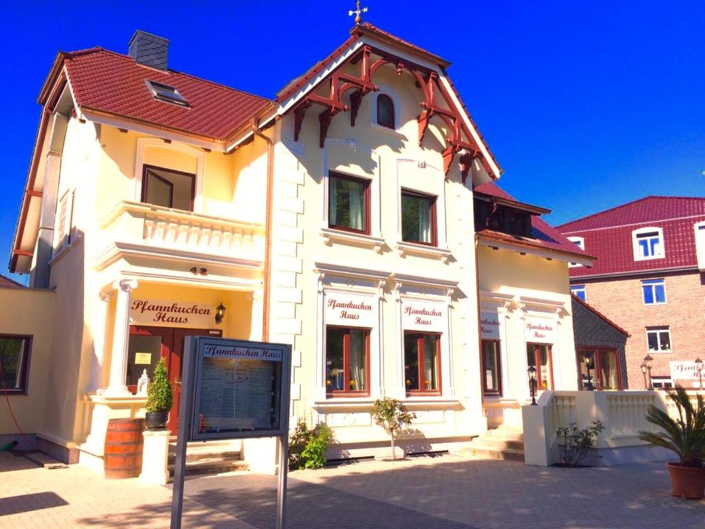 菲曼堡的住宿－Pfannkuchenhaus Fehmarn，前面有标志的白色建筑