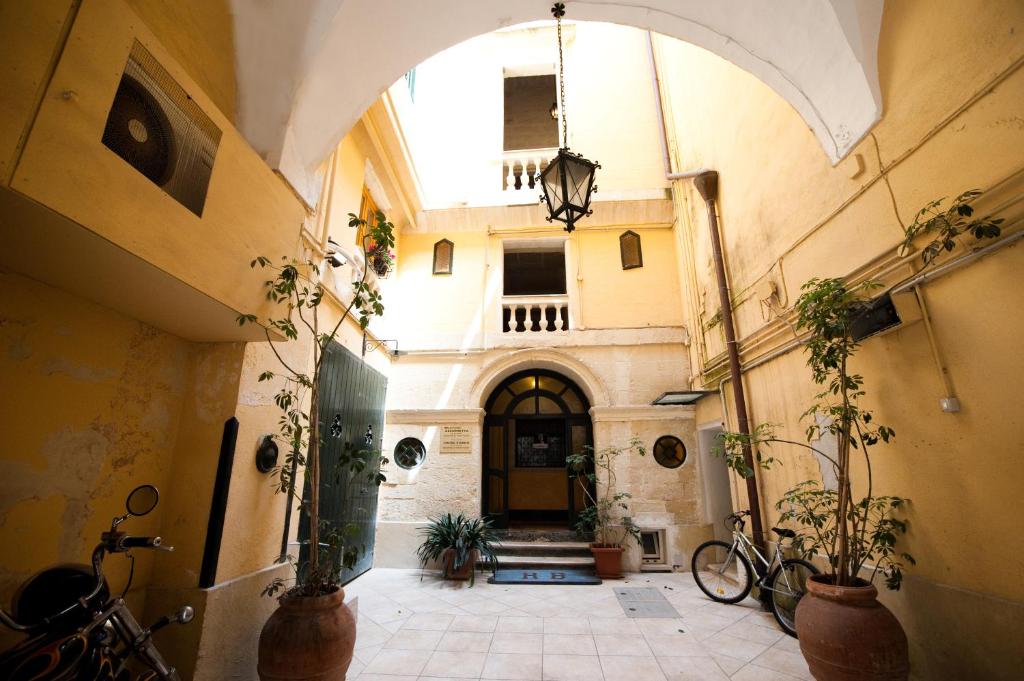 um corredor com uma arcada num edifício com plantas em Azzurretta Guest House em Lecce