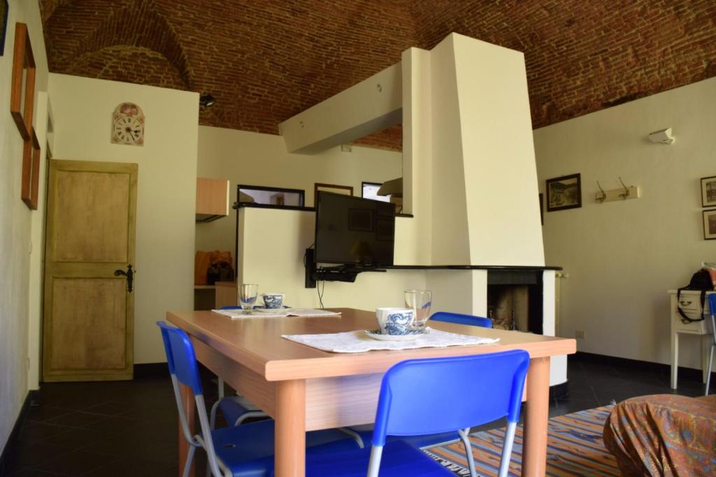 a dining room with a wooden table and blue chairs at Apartment Piazza XXV Aprile in Laigueglia