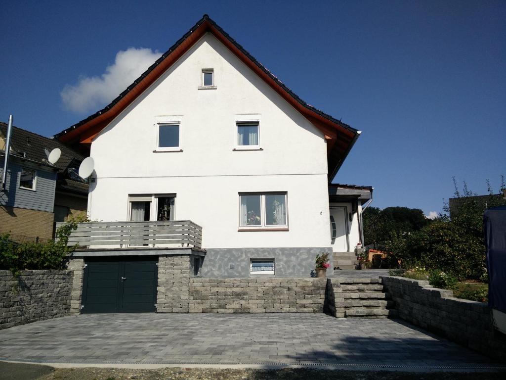 une maison blanche avec une grande allée. dans l'établissement Apartment Lidija, à Hiddenhausen