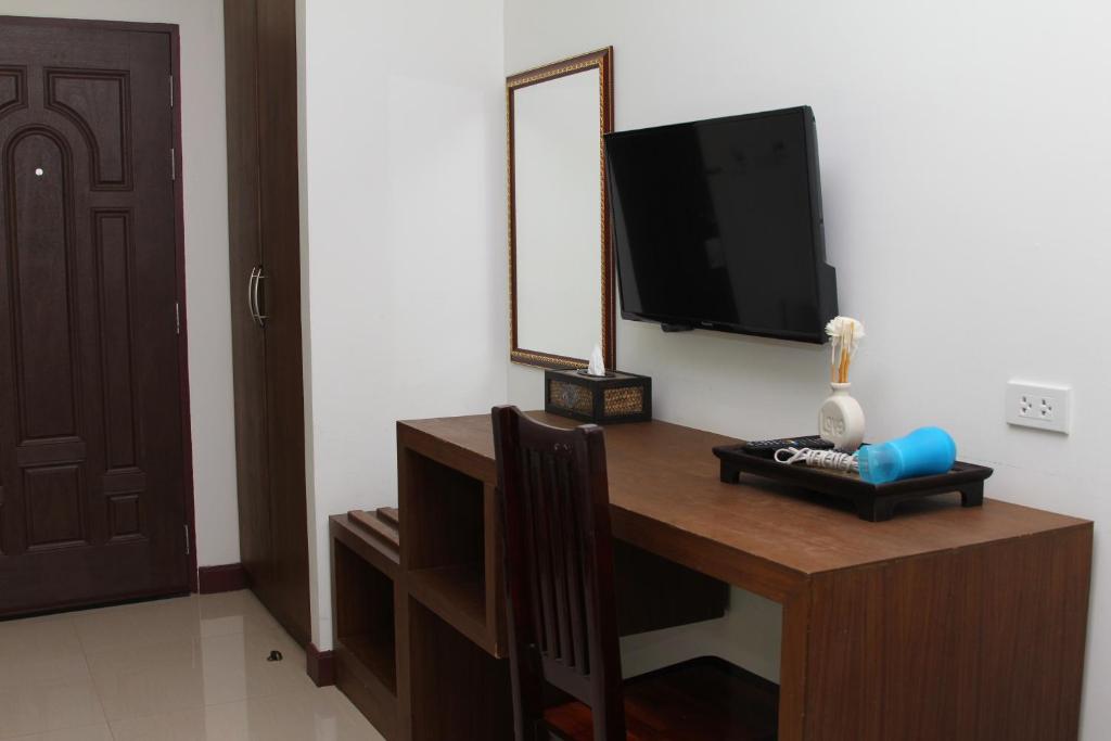 a room with a desk with a tv and a mirror at BS Airport at Phuket in Nai Yang Beach