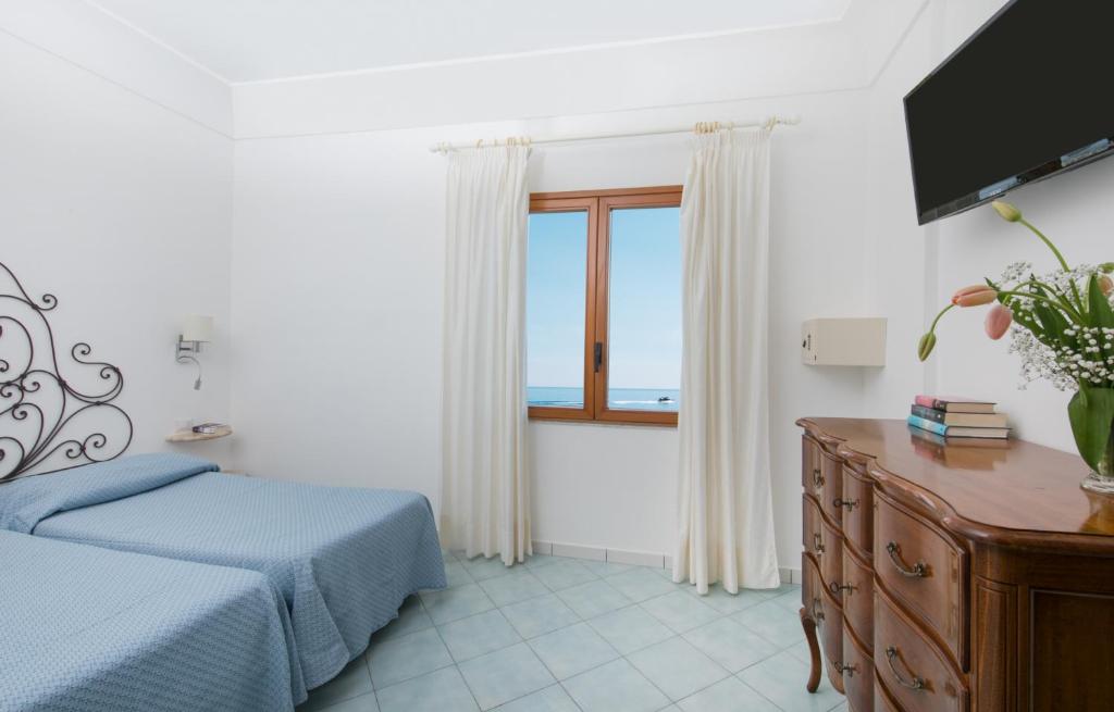 a bedroom with a bed and a window at Hotel Pupetto in Positano