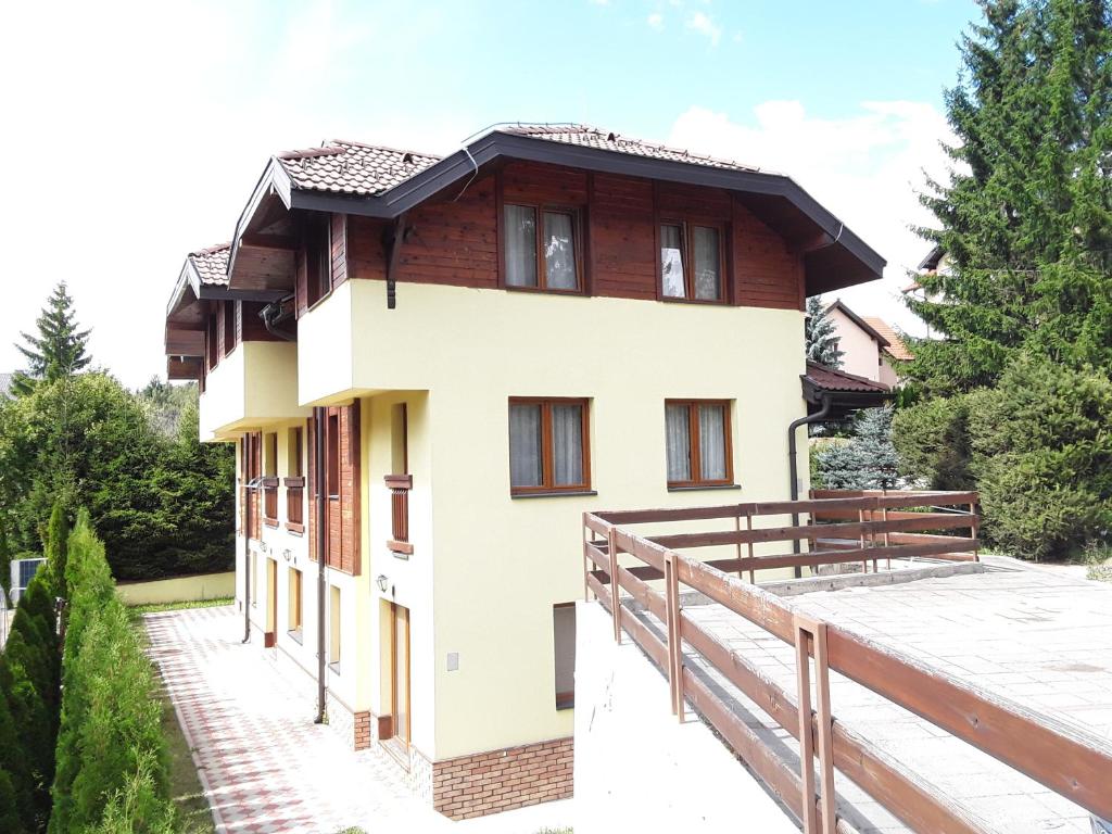 a house with a balcony and a wooden fence at Apartmani Ivanovic in Zlatibor