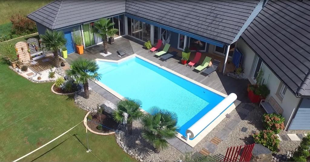 an overhead view of a swimming pool in front of a house at Escale en Correze in Sadroc