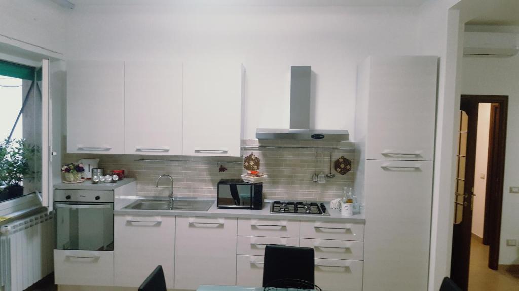 a white kitchen with a sink and a microwave at Casa Federica 1 in La Spezia