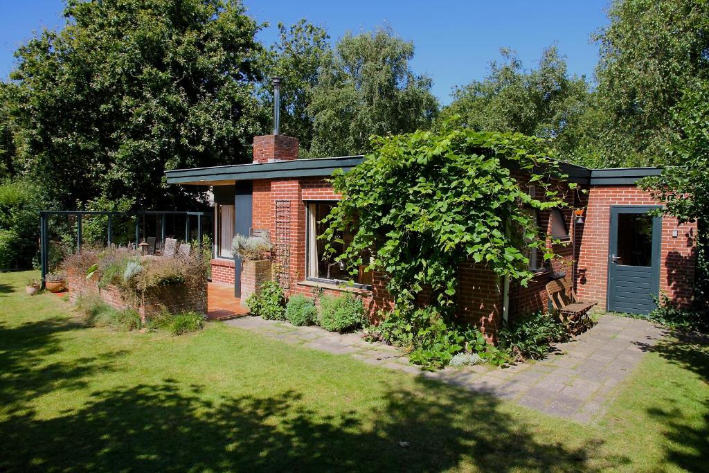 a brick house with a blue door in a yard at De Krukel in Westermient