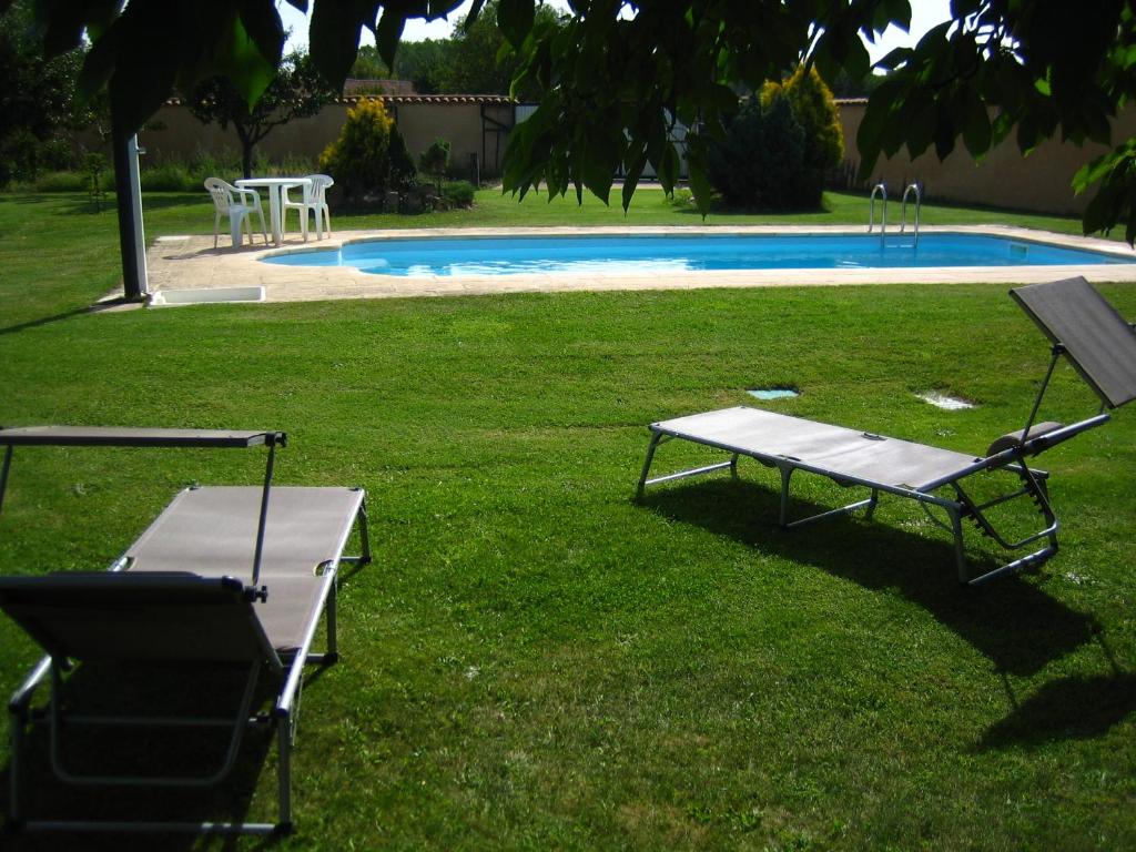 una mesa de picnic y un banco junto a una piscina en Casa Constanza en Vega de Infanzones