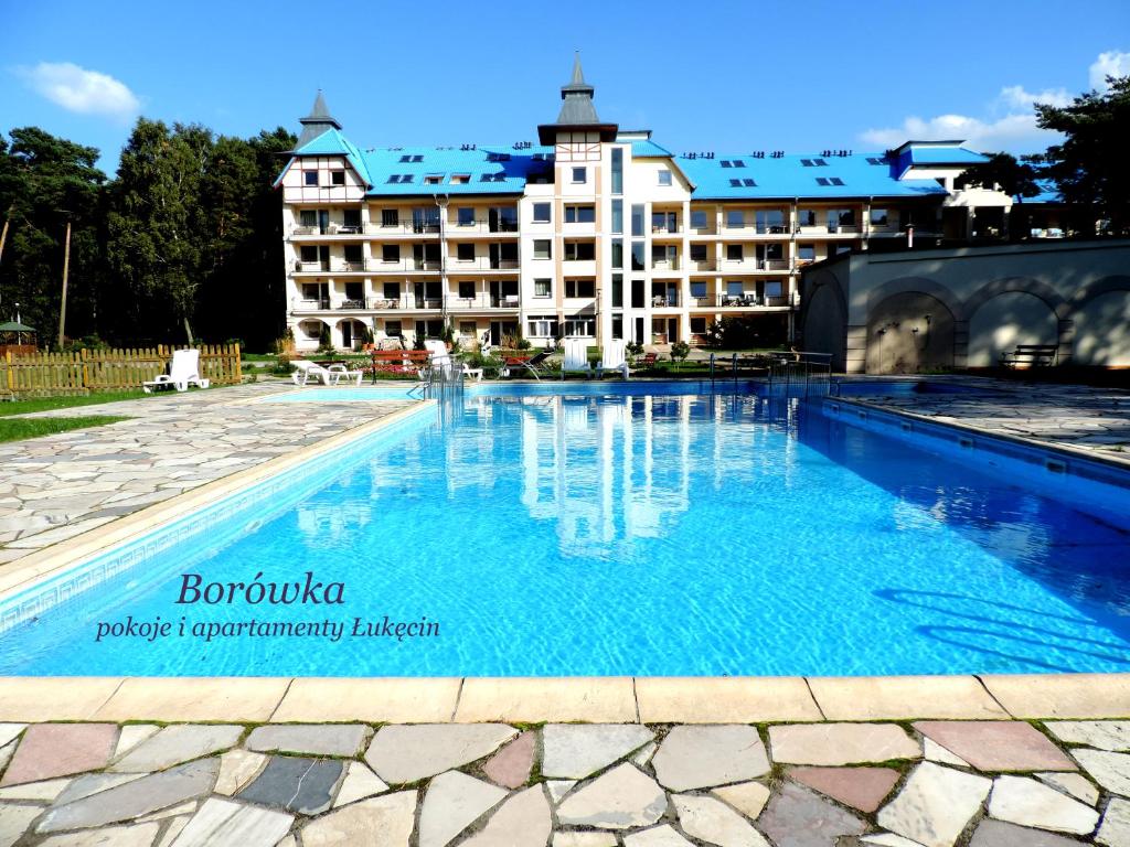 a large swimming pool in front of a hotel at Borówka w Blue Mare in Łukęcin