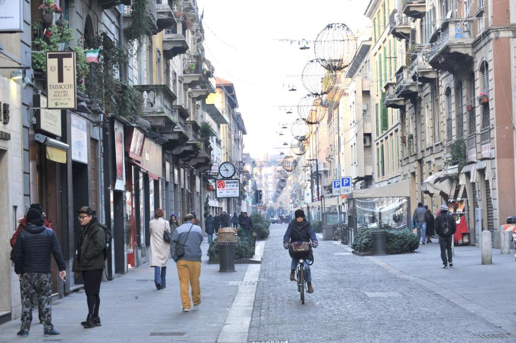 a group of people walking and riding bikes down a street at B&B Quater Lett in Milan